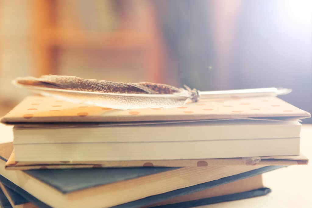 soft feather resting on a stack of books 2026 01 08 22 35 44 utc